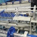 Рулон оцинкованной сетки-рабицы, столбы ограждения и крепежные элементы на белом фоне